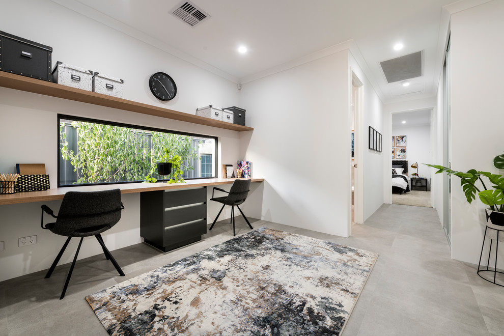 Foto di un ufficio minimal di medie dimensioni con pareti bianche, pavimento con piastrelle in ceramica, scrivania incassata e pavimento grigio