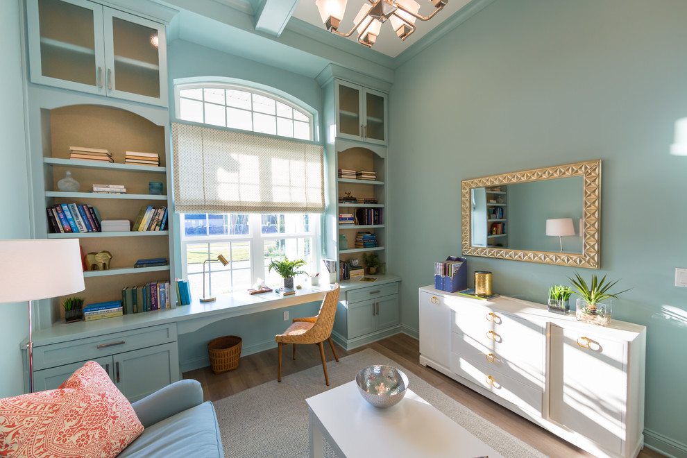 Cette image montre un bureau traditionnel de taille moyenne avec un mur bleu, un sol en bois brun et un bureau intégré.
