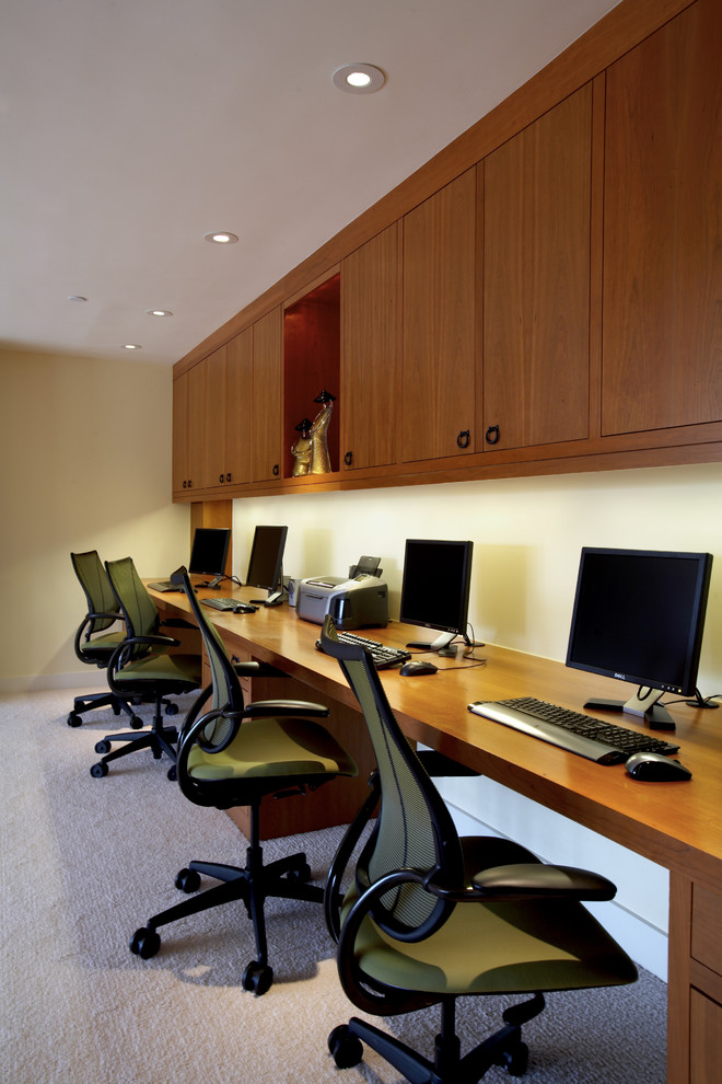 На фото: рабочее место среднего размера в современном стиле с бежевыми стенами, ковровым покрытием и встроенным рабочим столом