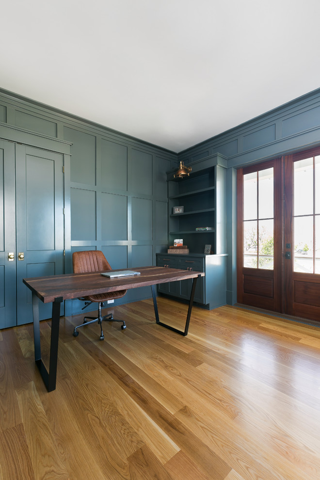 Großes Country Lesezimmer ohne Kamin mit blauer Wandfarbe, freistehendem Schreibtisch, braunem Holzboden und braunem Boden in Charleston