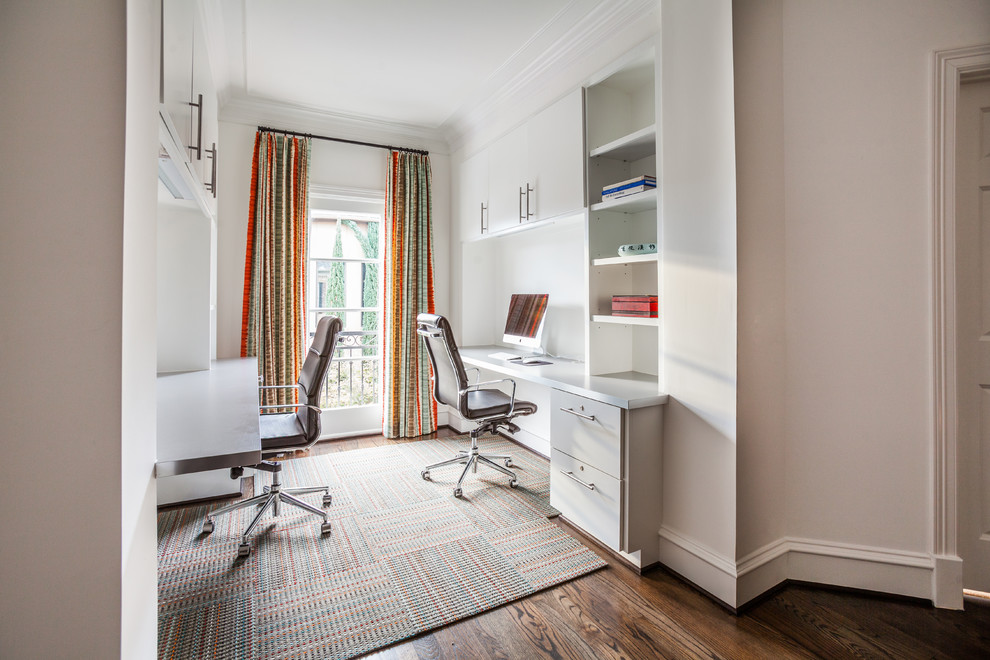 Imagen de despacho clásico renovado con paredes blancas, suelo de madera oscura y escritorio empotrado