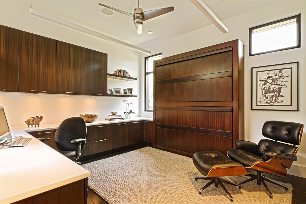 Immagine di uno studio minimalista con pavimento in legno massello medio e scrivania incassata