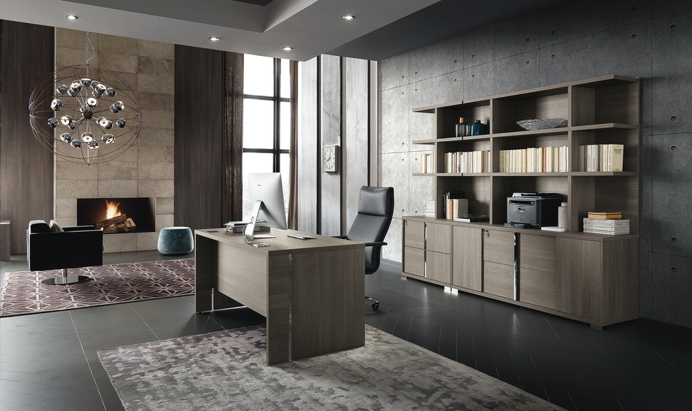 Diseño de despacho contemporáneo grande con paredes grises, suelo de madera oscura, todas las chimeneas, marco de chimenea de piedra, escritorio independiente y suelo negro