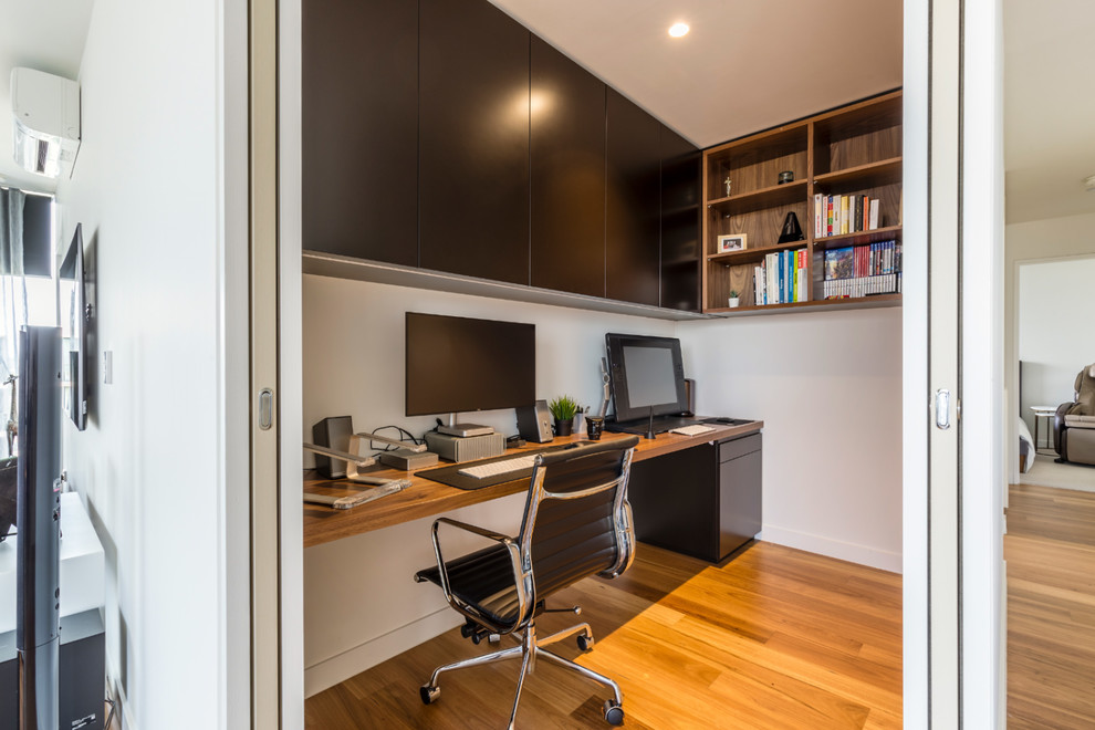 Foto di un ufficio design di medie dimensioni con pareti bianche, pavimento in legno massello medio e scrivania incassata