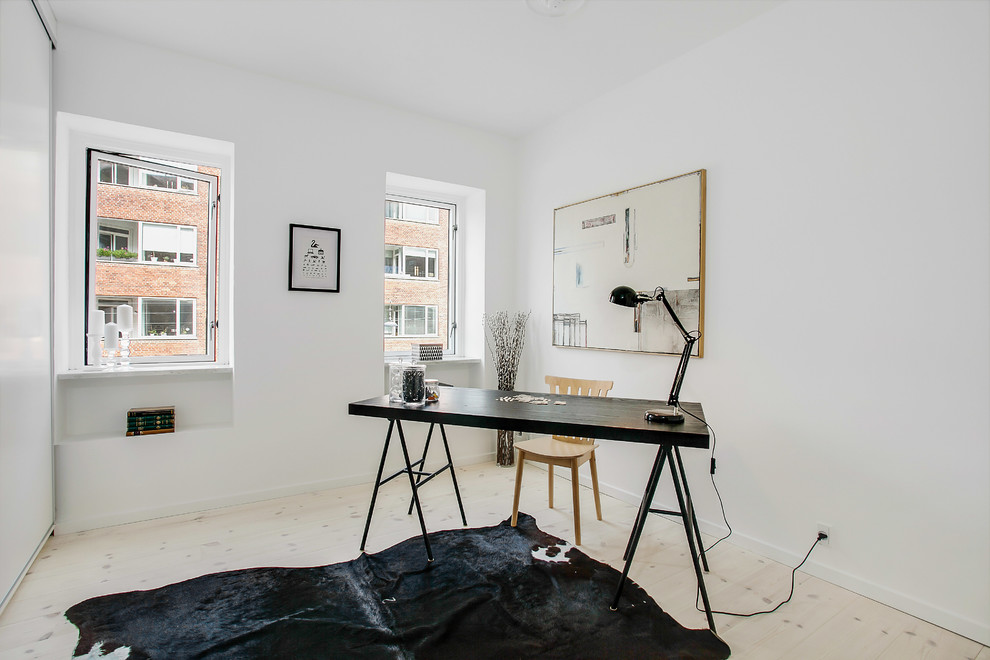 Idéer för mellanstora nordiska arbetsrum, med vita väggar, ljust trägolv och ett fristående skrivbord
