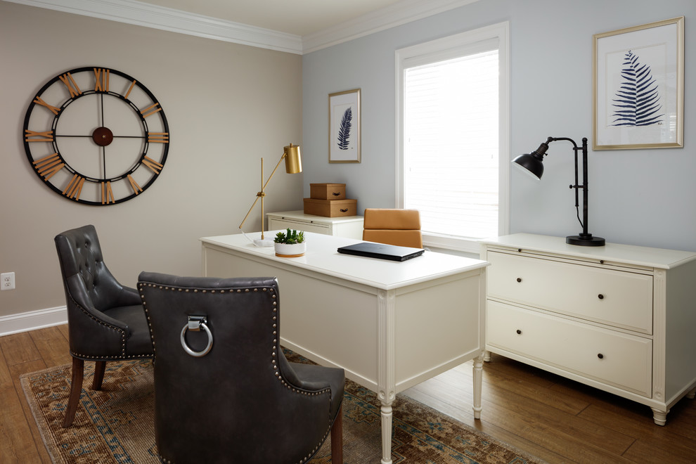 Esempio di un ufficio chic di medie dimensioni con pavimento in laminato, scrivania autoportante e pavimento marrone
