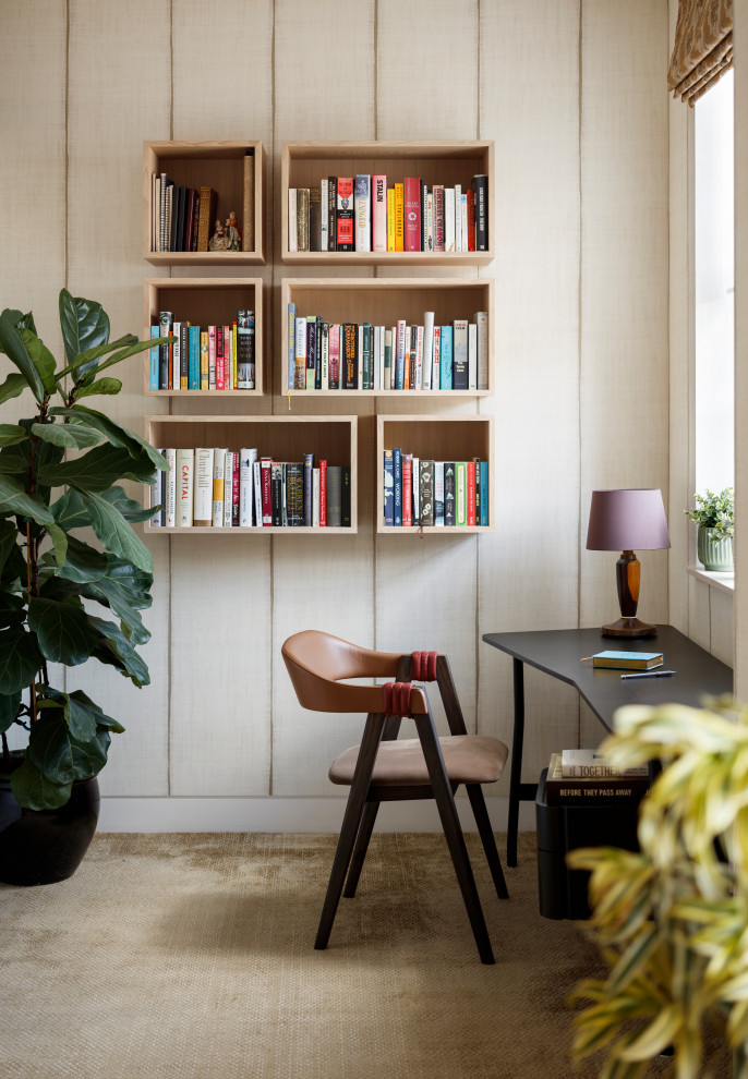 Modernes Arbeitszimmer ohne Kamin mit Arbeitsplatz, beiger Wandfarbe, Teppichboden, freistehendem Schreibtisch, braunem Boden und Wandpaneelen in London