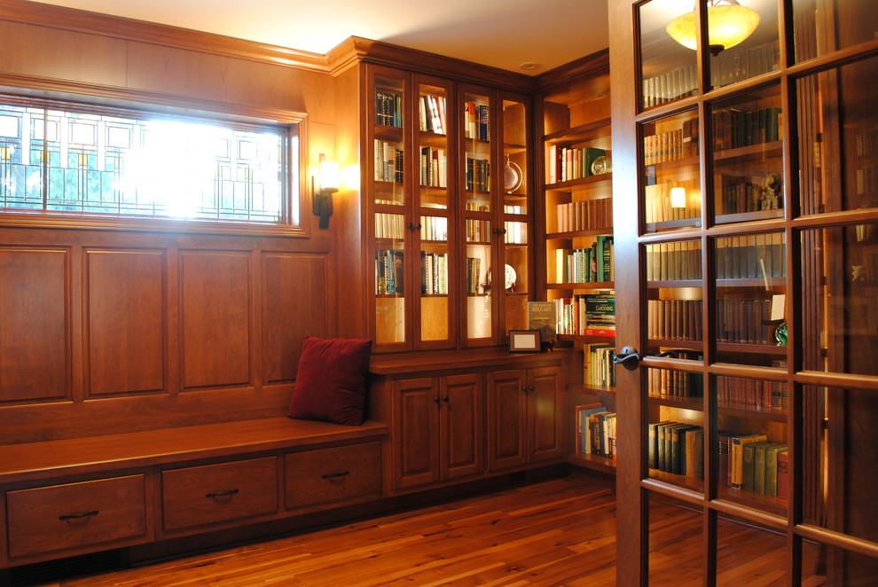 На фото: домашняя библиотека среднего размера в классическом стиле с паркетным полом среднего тона без камина с