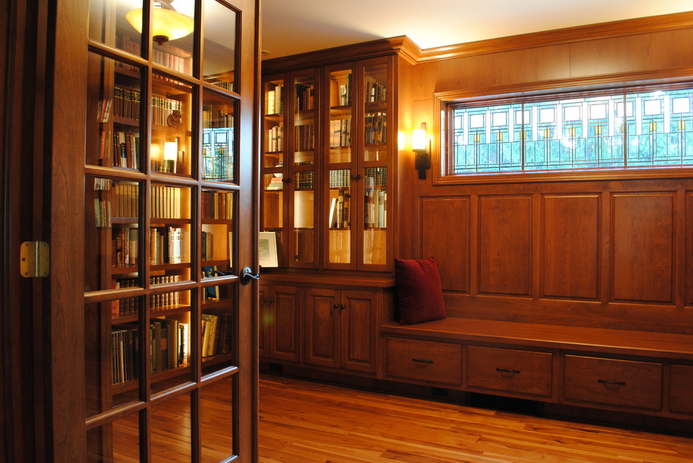 Cette image montre un bureau traditionnel de taille moyenne avec une bibliothèque ou un coin lecture, un sol en bois brun et aucune cheminée.