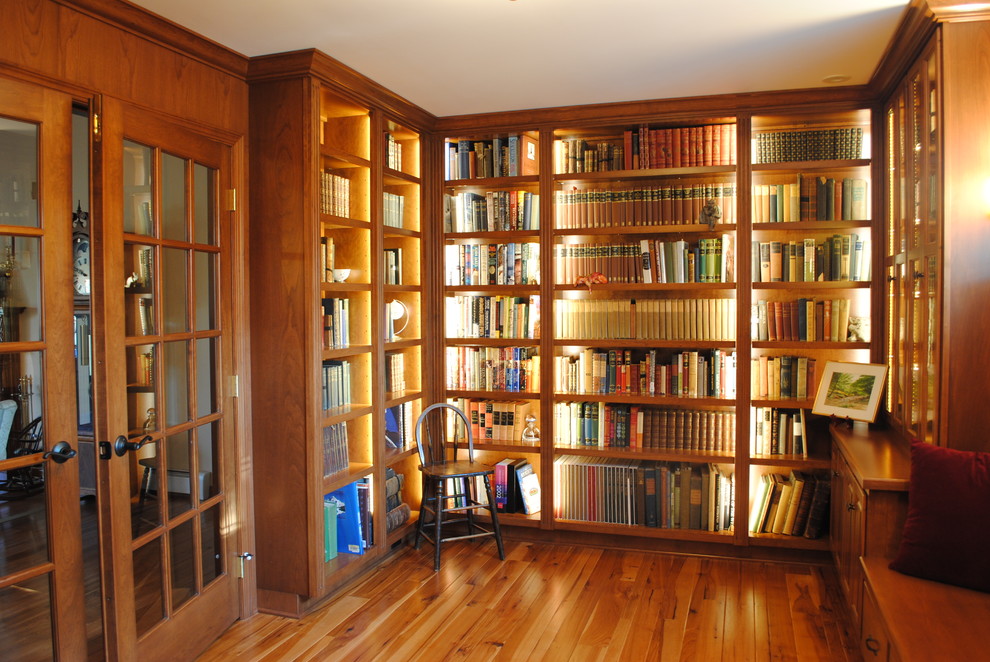 Ejemplo de despacho tradicional de tamaño medio sin chimenea con biblioteca y suelo de madera en tonos medios