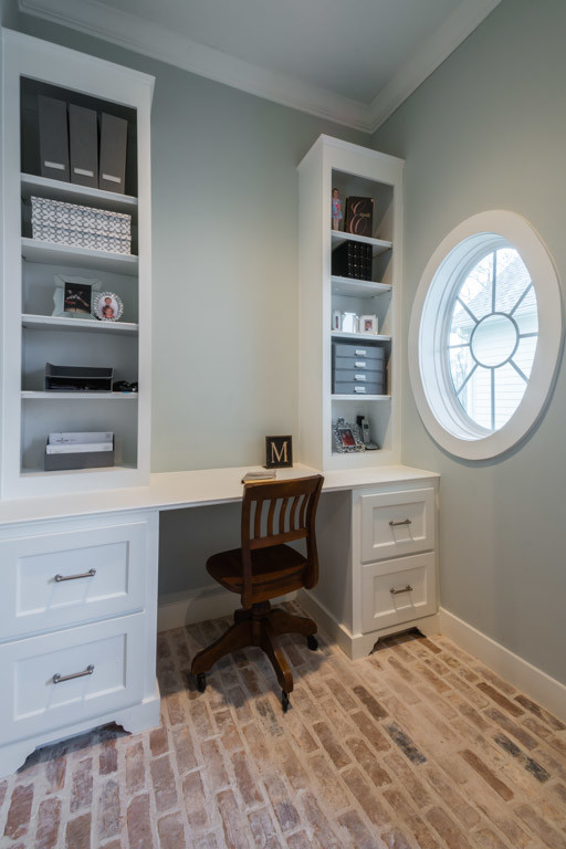 Inredning av ett klassiskt litet arbetsrum, med grå väggar, tegelgolv och ett inbyggt skrivbord