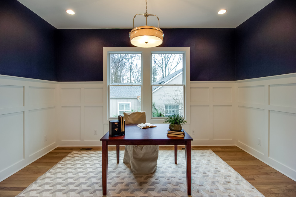 Modelo de despacho clásico de tamaño medio con paredes azules, suelo de madera clara, escritorio independiente y suelo marrón