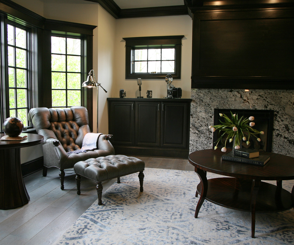 Cette photo montre un bureau de taille moyenne avec un mur gris, un sol en bois brun, une cheminée standard, un manteau de cheminée en pierre, un bureau indépendant et un sol gris.
