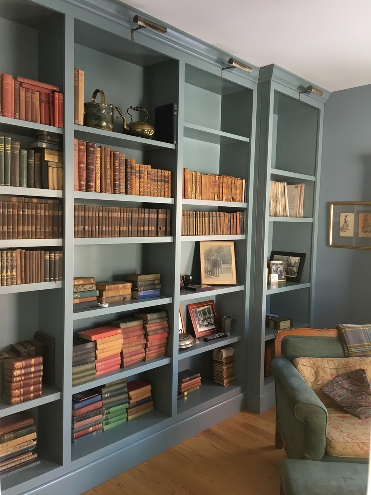 Idées déco pour un bureau campagne de taille moyenne avec une bibliothèque ou un coin lecture, un mur bleu, un sol en bois brun, aucune cheminée et un sol marron.