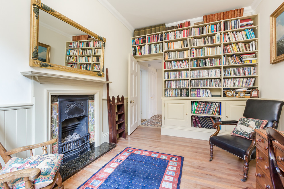 サリーにある高級な中くらいなトラディショナルスタイルのおしゃれなホームオフィス・書斎 (白い壁、淡色無垢フローリング、標準型暖炉、自立型机) の写真