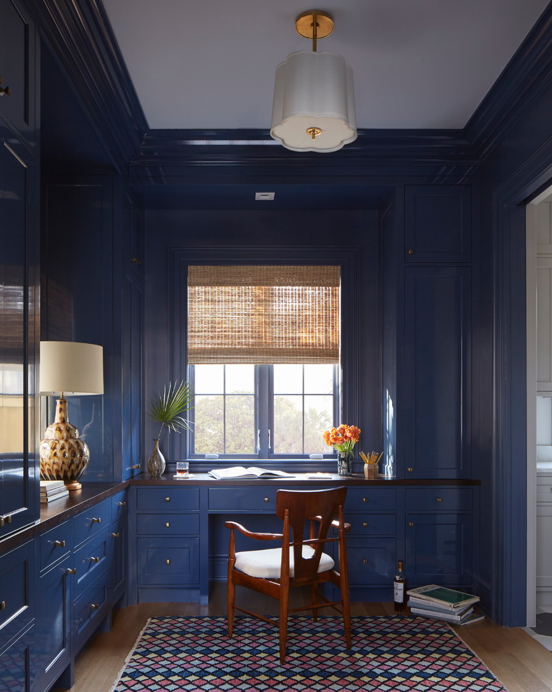 Modelo de despacho clásico con paredes azules, suelo de madera clara y escritorio empotrado