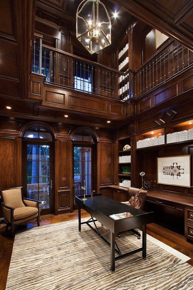 Свежая идея для дизайна: огромный домашняя библиотека в классическом стиле с коричневыми стенами, темным паркетным полом и отдельно стоящим рабочим столом без камина - отличное фото интерьера
