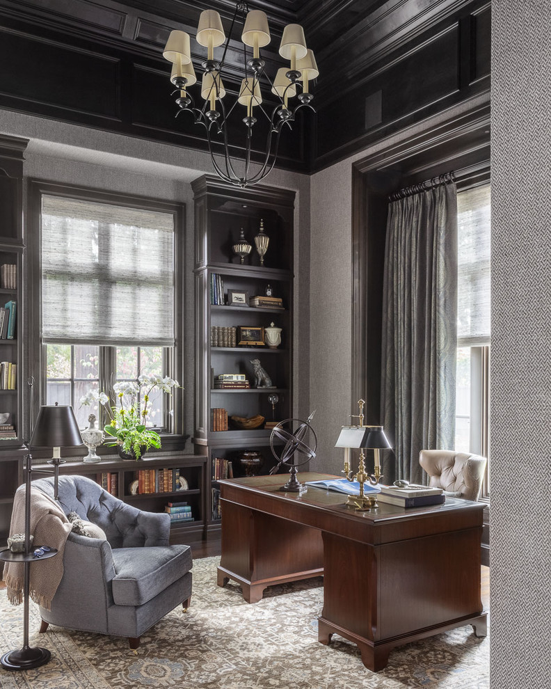 Diseño de despacho tradicional con paredes grises, suelo de madera oscura y escritorio independiente