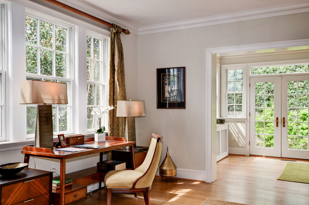 Ispirazione per uno studio tradizionale con pareti beige, pavimento in legno massello medio, scrivania autoportante e pavimento marrone