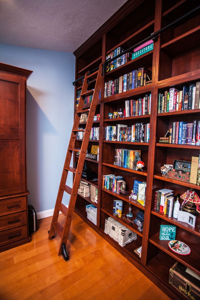 Idéer för ett mellanstort klassiskt arbetsrum, med ett bibliotek, blå väggar, mellanmörkt trägolv, ett inbyggt skrivbord och brunt golv