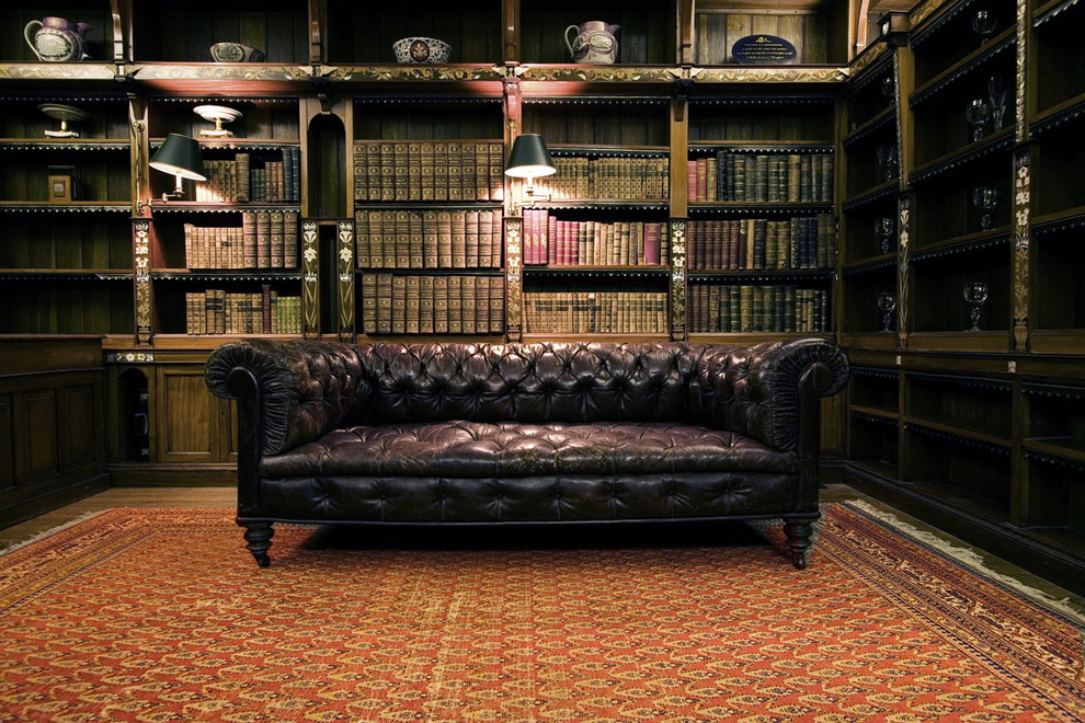 Источник вдохновения для домашнего уюта: домашняя библиотека среднего размера в классическом стиле с коричневыми стенами, темным паркетным полом, отдельно стоящим рабочим столом и коричневым полом без камина