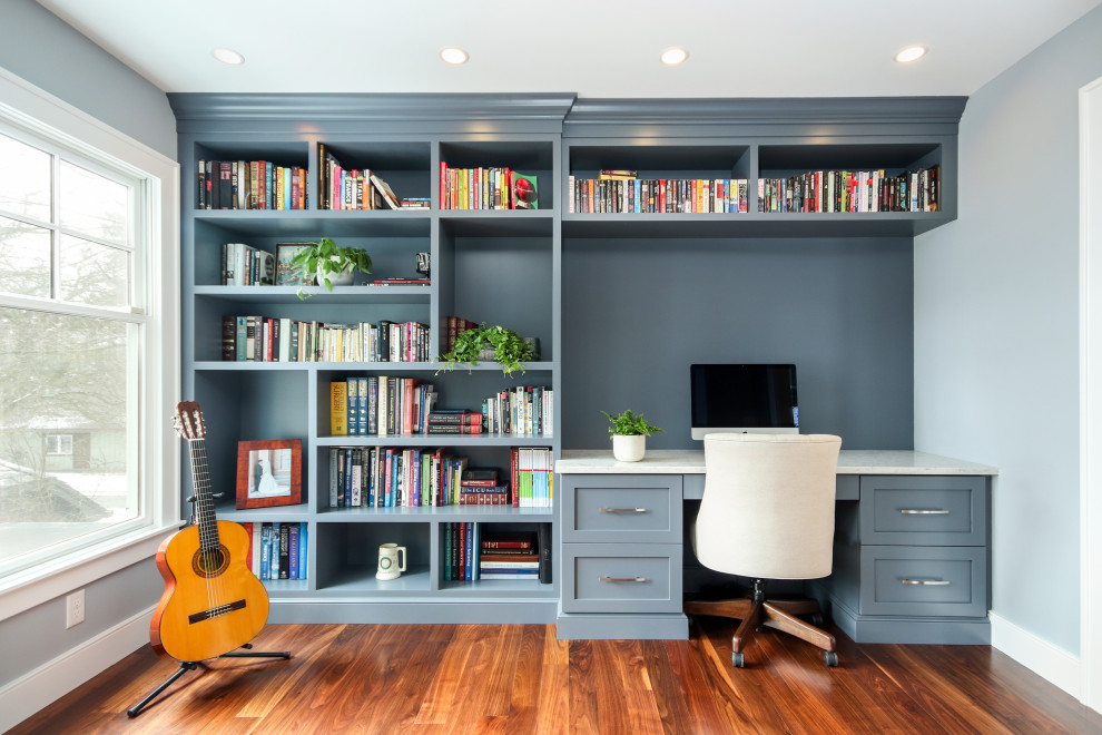 Exempel på ett klassiskt arbetsrum, med blå väggar, mörkt trägolv, ett inbyggt skrivbord och brunt golv