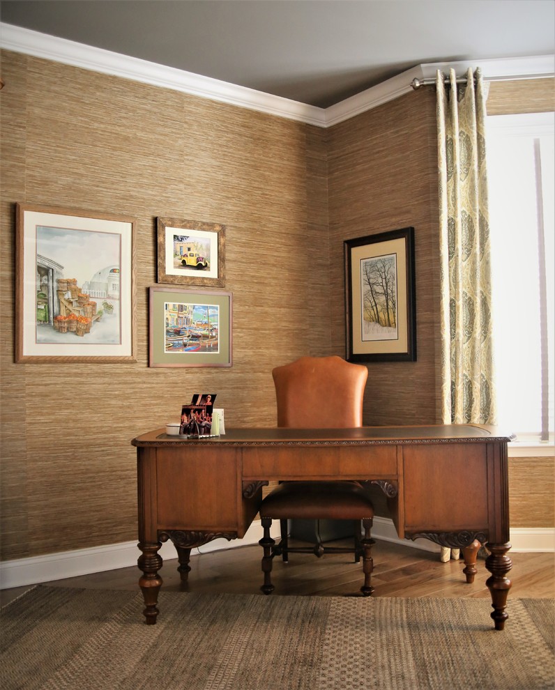 Foto på ett vintage arbetsrum, med beige väggar, mellanmörkt trägolv och ett fristående skrivbord