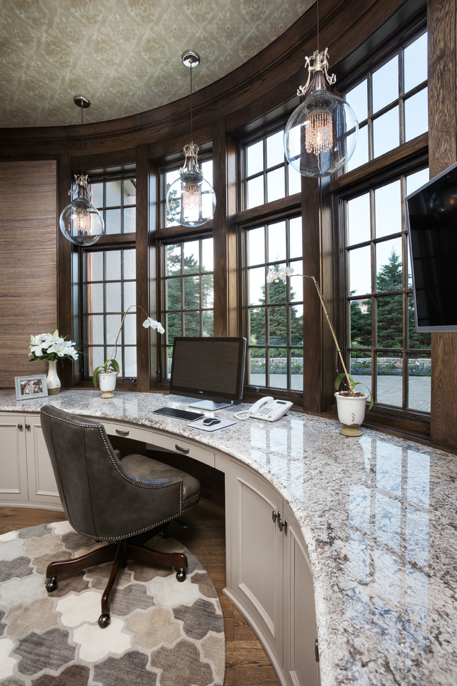 Diseño de despacho clásico sin chimenea con paredes marrones, suelo de madera oscura y escritorio empotrado