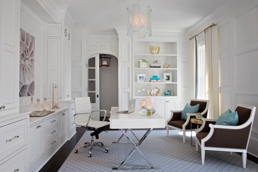 Modelo de despacho clásico sin chimenea con paredes blancas, suelo de madera oscura y escritorio independiente