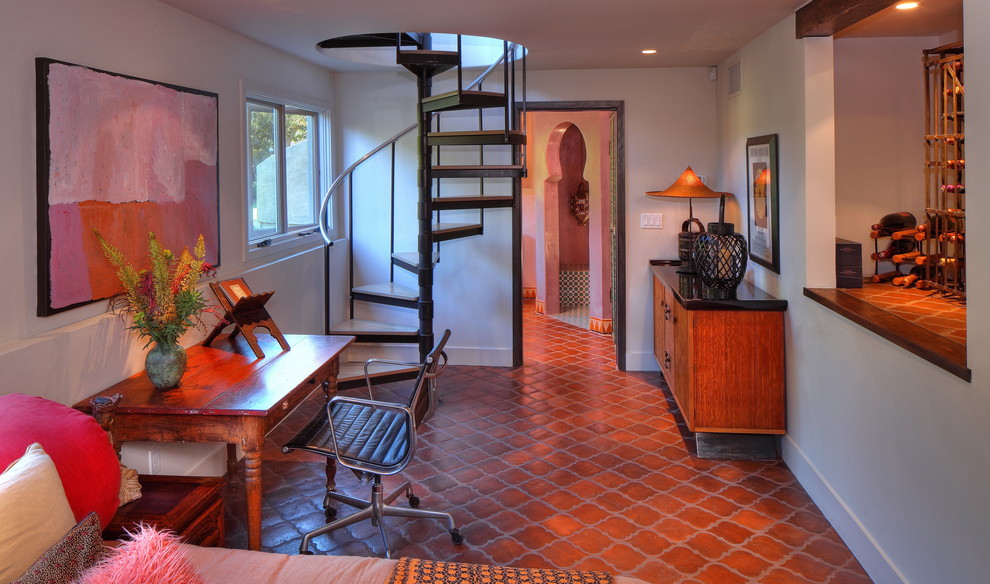 ロサンゼルスにある地中海スタイルのおしゃれなホームオフィス・書斎 (テラコッタタイルの床、白い壁、自立型机、赤い床) の写真