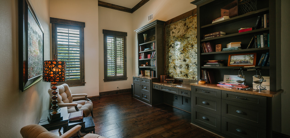 Großes Klassisches Arbeitszimmer ohne Kamin mit braunem Holzboden, Einbau-Schreibtisch, beiger Wandfarbe und Arbeitsplatz in Houston