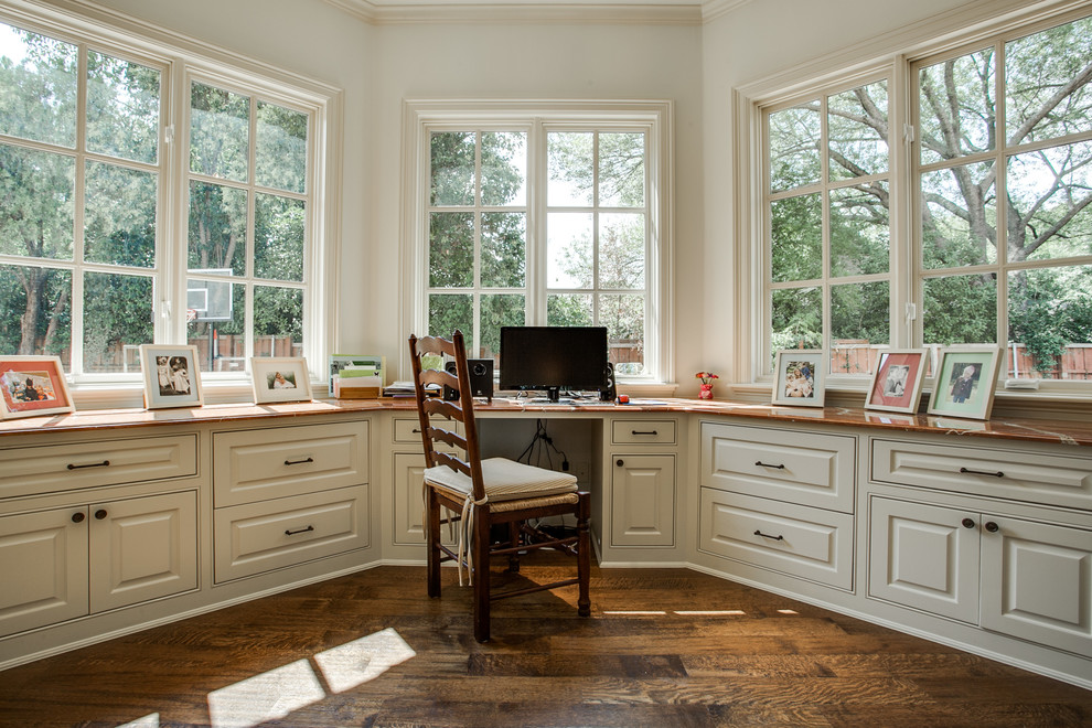This is an example of a classic home office in Dallas with white walls, medium hardwood flooring and a built-in desk.