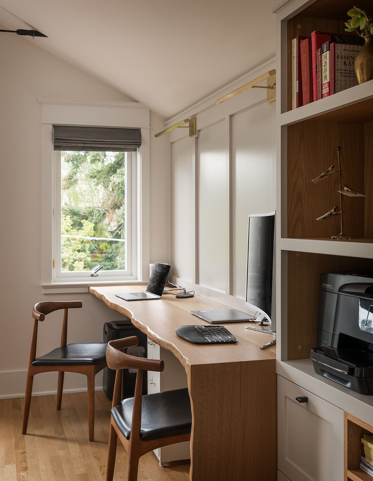 Diseño de despacho tradicional renovado con paredes blancas, suelo de madera clara y escritorio empotrado