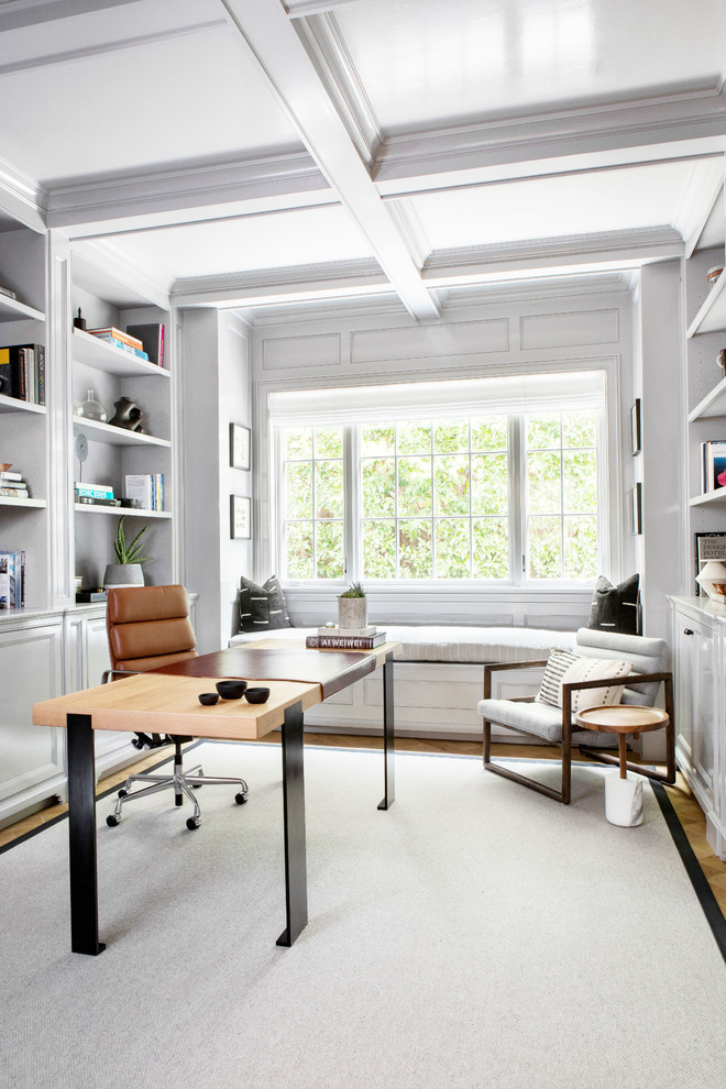Großes Klassisches Arbeitszimmer mit Arbeitsplatz, grauer Wandfarbe, freistehendem Schreibtisch, braunem Holzboden und braunem Boden in New York