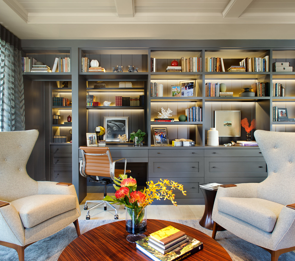 This is an example of a classic home office in San Diego with light hardwood flooring and a built-in desk.