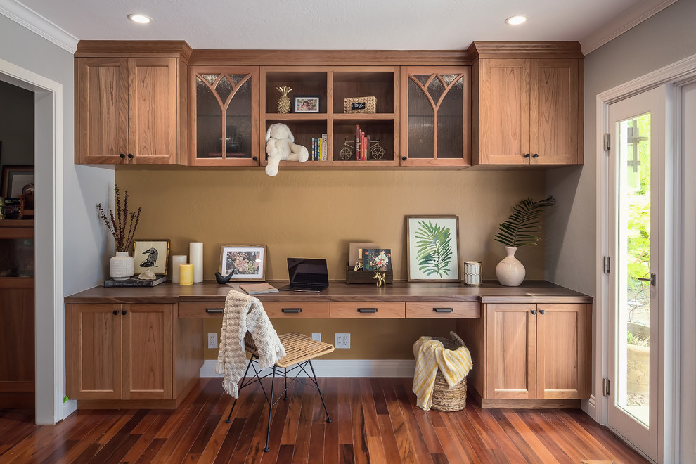 Photo of a medium sized traditional study in San Francisco with no fireplace, a built-in desk, brown floors, brown walls and dark hardwood flooring.