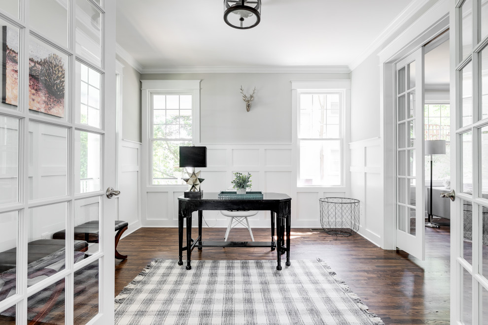 Mittelgroßes Klassisches Arbeitszimmer mit Arbeitsplatz, grauer Wandfarbe, freistehendem Schreibtisch, braunem Boden, dunklem Holzboden und vertäfelten Wänden in Richmond
