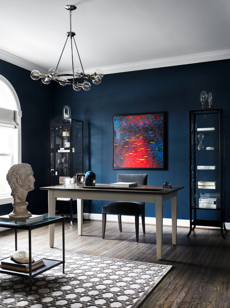 Transitional freestanding desk dark wood floor and brown floor home office photo in New York with blue walls