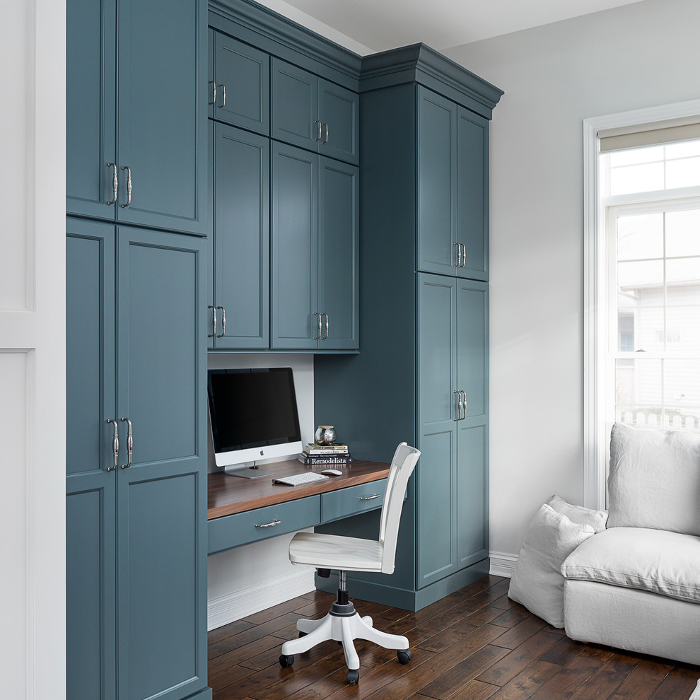 Foto de despacho clásico renovado de tamaño medio con paredes grises, suelo de madera oscura, escritorio empotrado y suelo marrón
