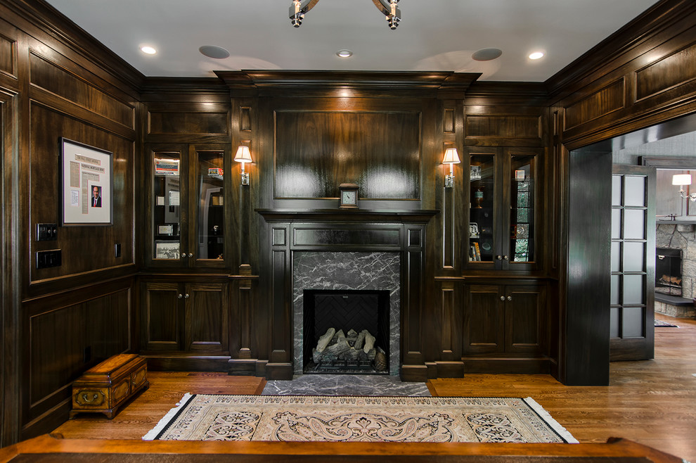 This is an example of a medium sized classic home office in New York with dark hardwood flooring, a standard fireplace and a tiled fireplace surround.