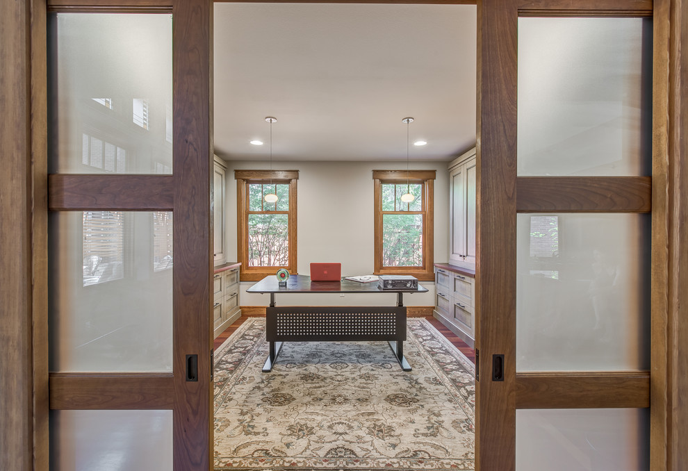 Mittelgroßes Klassisches Arbeitszimmer ohne Kamin mit beiger Wandfarbe, braunem Holzboden und freistehendem Schreibtisch in Denver