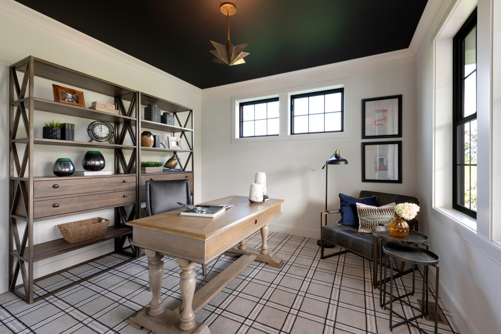 Klassisk inredning av ett arbetsrum, med heltäckningsmatta, ett fristående skrivbord, grått golv och vita väggar
