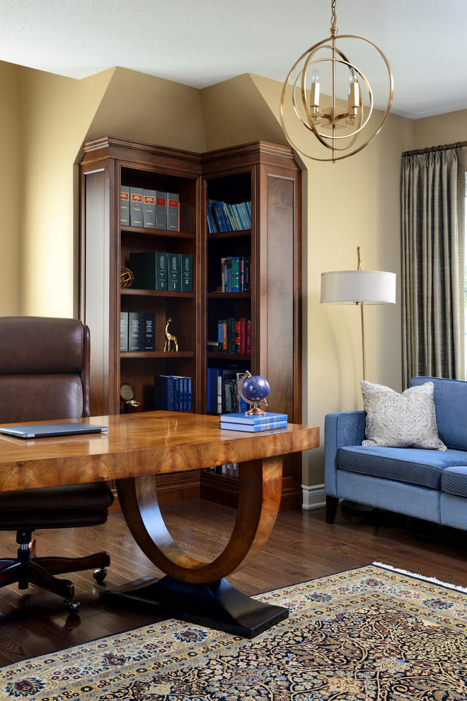 Example of a mid-sized transitional freestanding desk dark wood floor and brown floor home office library design in Toronto with yellow walls and no fireplace