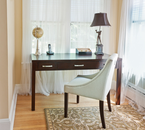 Ejemplo de despacho clásico renovado pequeño con paredes beige, suelo de madera clara y escritorio independiente