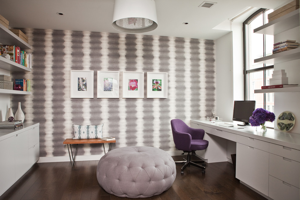 Foto på ett funkis arbetsrum, med grå väggar, mörkt trägolv och ett inbyggt skrivbord