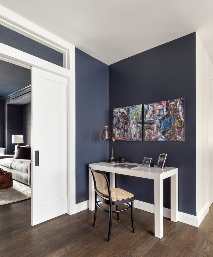 This is an example of a scandi study in New York with blue walls, dark hardwood flooring, no fireplace and a freestanding desk.