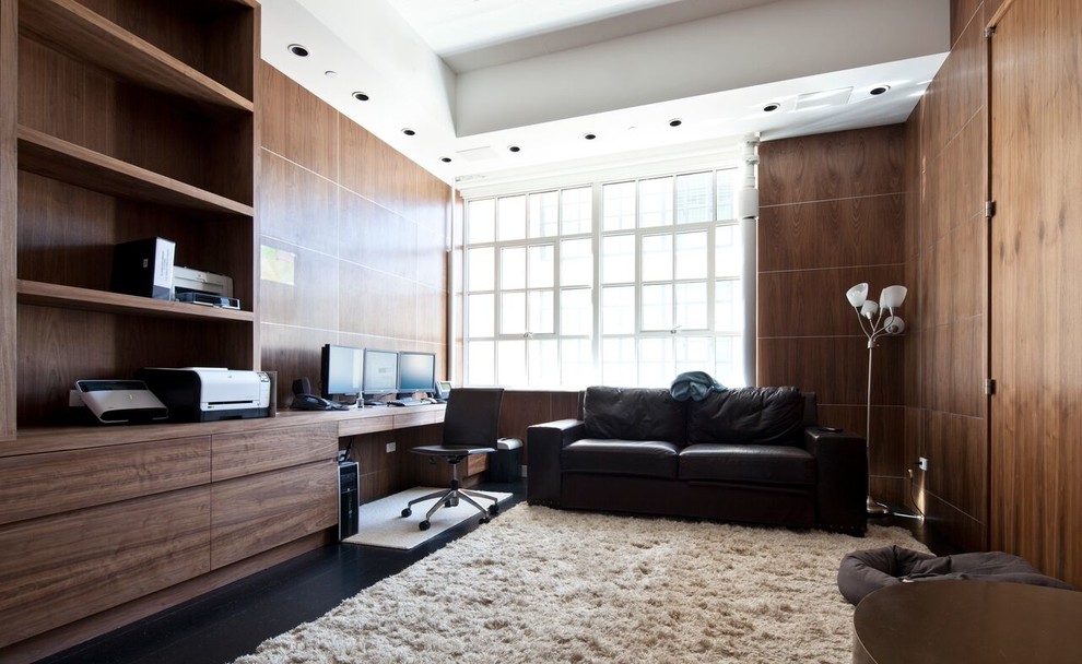 Geräumiges Modernes Arbeitszimmer ohne Kamin mit Arbeitsplatz, brauner Wandfarbe, dunklem Holzboden, Einbau-Schreibtisch und schwarzem Boden in New York