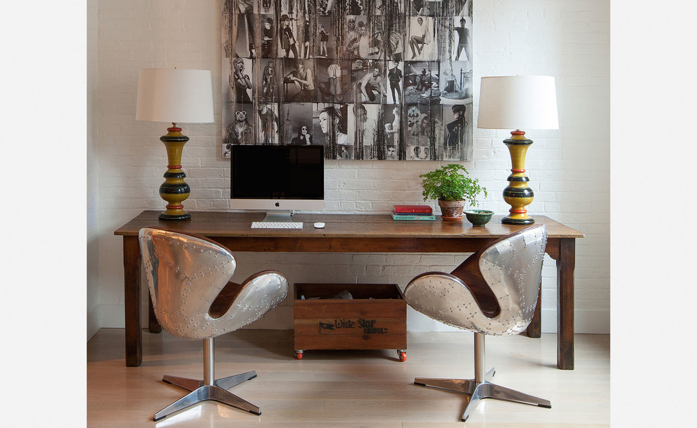 This is an example of a medium sized contemporary study in New York with white walls, light hardwood flooring, no fireplace and a freestanding desk.