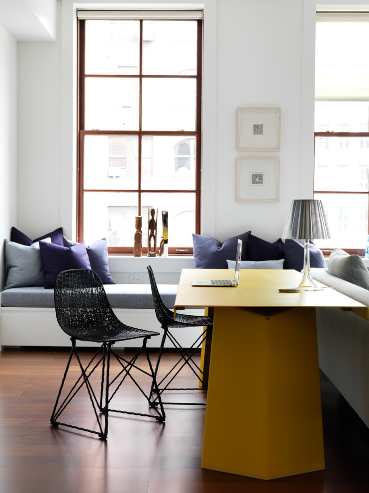 Modernes Arbeitszimmer mit weißer Wandfarbe, braunem Holzboden und freistehendem Schreibtisch in New York