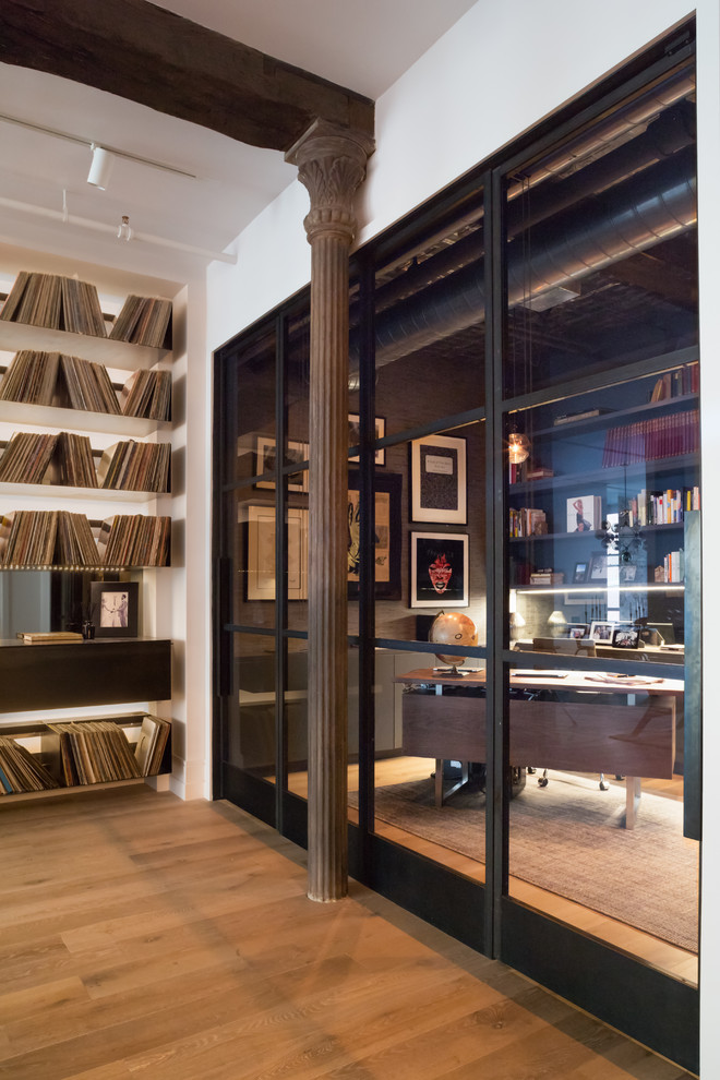 Idéer för mellanstora industriella hemmabibliotek, med grå väggar, ljust trägolv och ett fristående skrivbord
